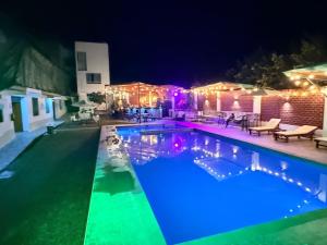 a swimming pool lit up at night with lights at MAR y LAGO EXPERIENCE in Lunahuaná