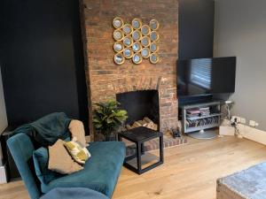 a living room with a fireplace and a tv at Seaside 4 bed terraced house in Hastings