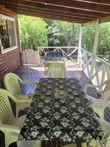 a table and chairs on a screened porch with a table and chairs at Cabaña bruji in Tigre