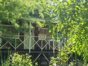 a wooden house with a porch with a fence at Cabaña bruji in Tigre