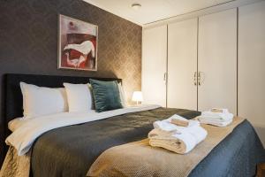 a bedroom with a large bed with towels on it at Guestly Homes - Spacious Top Floor 2BR Residence in Luleå