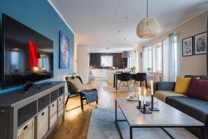a living room with a couch and a tv at Guestly Homes - Spacious Top Floor 2BR Residence in Luleå