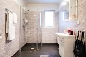 a bathroom with a shower and a sink at Guestly Homes - Spacious Top Floor 2BR Residence in Luleå +30 photos