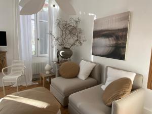 a living room with a couch and a chair at La maison sur la place in Penne-dʼAgenais