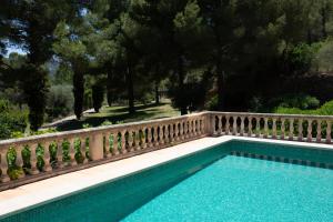 a swimming pool with a fence and trees at Villa Sophia in Port d'Andratx