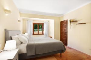 a bedroom with a bed and a window at Villa Sophia in Port d'Andratx