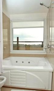 a white bath tub in a bathroom with a window at Linda Bay Beach & Resort in Mar de las Pampas