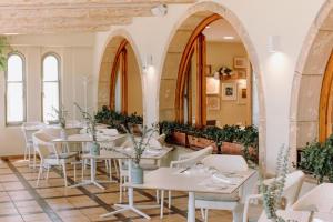 a restaurant with white tables and white chairs at Hotel Los Ángeles Denia in Denia