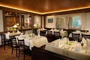 a restaurant with tables and chairs with white table cloth at Hotel Restaurant Lüdenbach in Overath