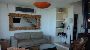 ein Wohnzimmer mit einem Sofa und einem Spiegel in der Unterkunft Linda Bay Beach & Resort in Mar de las Pampas