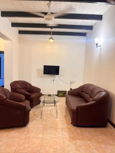 a living room with two leather chairs and a table at Woradi Solitude Bungalow in Talpe