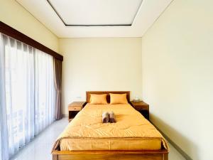 a bedroom with a dog laying on a bed at Umah Anami in Jimbaran