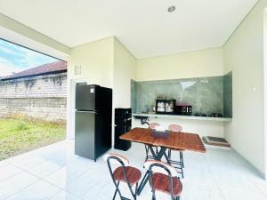 a kitchen with a table and chairs and a refrigerator at Umah Anami in Jimbaran