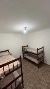 a room with three bunk beds against a wall at JK Casa de Praia in Ilha Comprida