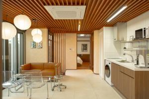 a living room with a couch and a table and a kitchen at Staykor Busan in Pusan
