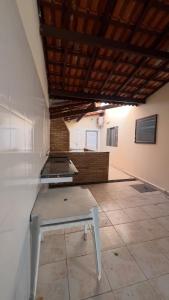 a kitchen with a table in the middle of a room at JK Casa de Praia in Ilha Comprida