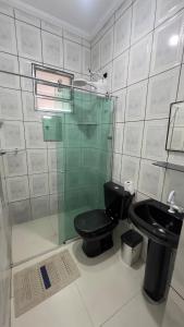 a bathroom with a black toilet and a sink at JK Casa de Praia in Ilha Comprida +22 photos