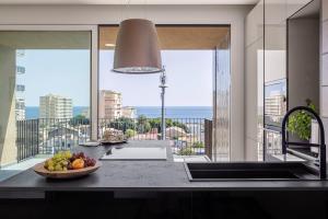 a kitchen with a bowl of fruit on a counter at Top-Floor Sea View with Pool Access in Catania +14 photos