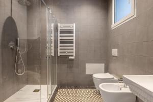 a bathroom with a shower and a toilet and a sink at Top-Floor Sea View with Pool Access in Catania