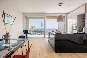 a kitchen with a glass counter and a large window at Top-Floor Sea View with Pool Access in Catania
