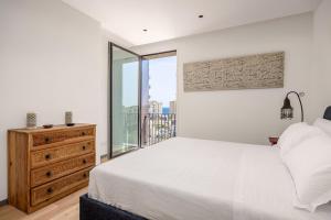 a bedroom with a white bed and a window at Top-Floor Sea View with Pool Access in Catania