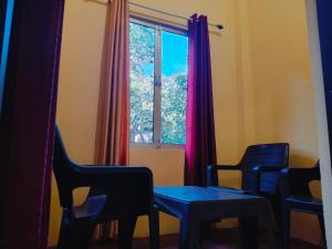 a room with two chairs and a table and a window at Corbett Bungalow Stay- Private Garden Stay Near Jim Corbett in Rāmnagar