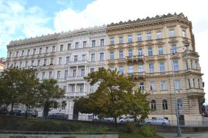 un gran edificio blanco con coches estacionados frente a él en Valentina Apartments en Praga