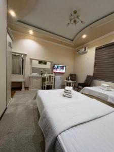 a bedroom with two beds and a living room at Amina in Samarkand