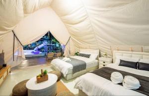 a tent bedroom with two beds and a playground at kingdom glamping in North Pattaya