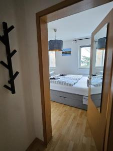 a room with a bed and a window and a mirror at Seepavillon Rheinsberg in Rheinsberg