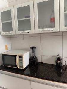 a microwave on a counter in a kitchen at Cantim da tranquilidade in Sobral +12 photos