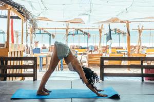 a woman doing a handstand on a blue yoga mat at Drift Bay in Arugam Bay