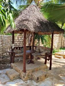 a small hut with a chair and a table at MALKIA SUITEs in Diani Beach
