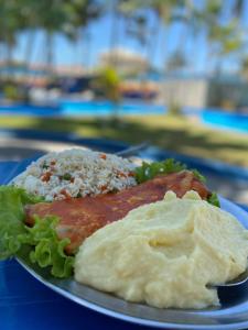 a plate of food with rice and meat and lettuce at Fiesta Park Hotel in Jacobina