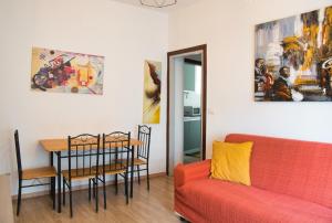 a living room with a red couch and a table at Tana del Manzoni in Barzio