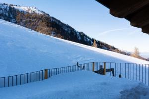 a snow covered slope with a fence on a ski slope at Chalet Burrino in Frabosa Soprana