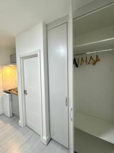a white closet with a door in a room at Cozy Golders Green Studio Flat in Moffat