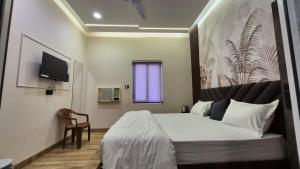 a hotel room with a bed and a tv at Hotel MRK VILLA in Varanasi