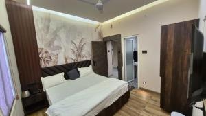 a bedroom with a bed with a large headboard at Hotel MRK VILLA in Varanasi