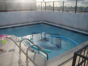 una piscina de agua azul en un edificio en Apartamento Ametista 6, en Maceió