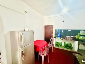 a kitchen with a red table and a refrigerator at Long Beach Homestay in Tangalle