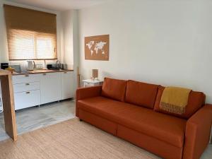 a living room with a couch and a kitchen at Studio-Guest House with Jacuzzi Spa and Sauna in Espartinas