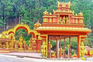 a yellow and orange building with gold statues on it at Cool feel rest and cafe in Nuwara Eliya