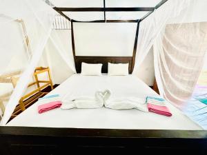 a bedroom with a bed with two towels on it at Long Beach Homestay in Tangalle