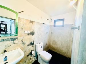 a bathroom with a toilet and a sink at Long Beach Homestay in Tangalle +21 photos