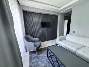 a living room with a couch and a chair and a table at Ege Suit in Buca