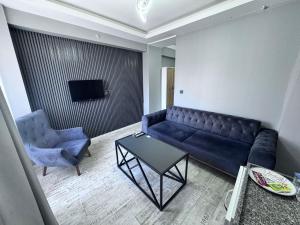 a living room with a couch and a chair and a table at Ege Suit in Buca +3 photos