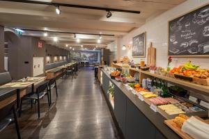 a restaurant with a buffet line with fruits and vegetables at Nova Hotel in Amsterdam