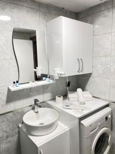 a bathroom with a sink and a washing machine at Ege Suit in Buca