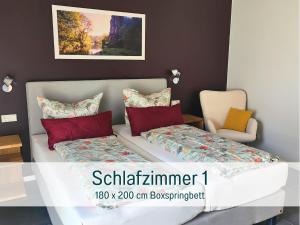 ein Schlafzimmer mit einem Bett, einer Couch und einem Stuhl in der Unterkunft Traumweiler Ferienhäuser am Nationalpark Hunsrück Hochwald - barriearm - mit effektiver Kühlung in Kirschweiler